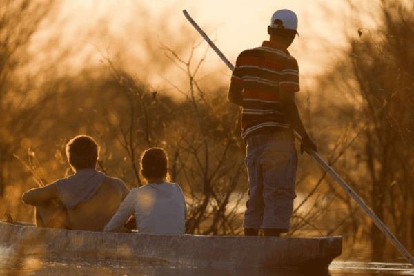 Guests on a mokoro safari through the Okavango Delta